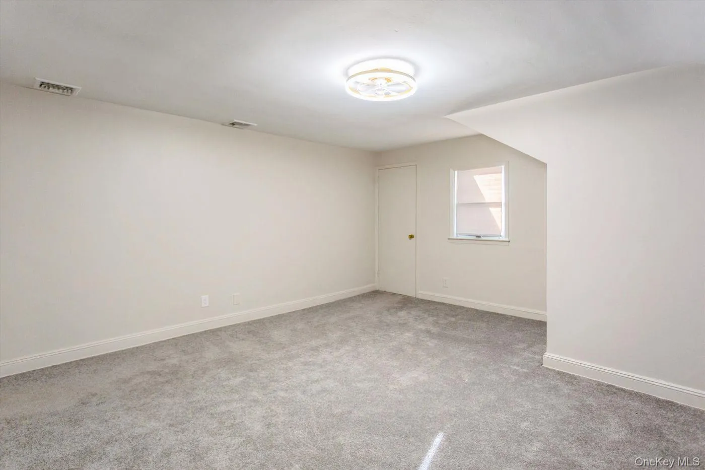 Empty room with light carpet and baseboards Empty room with light carpet and baseboards