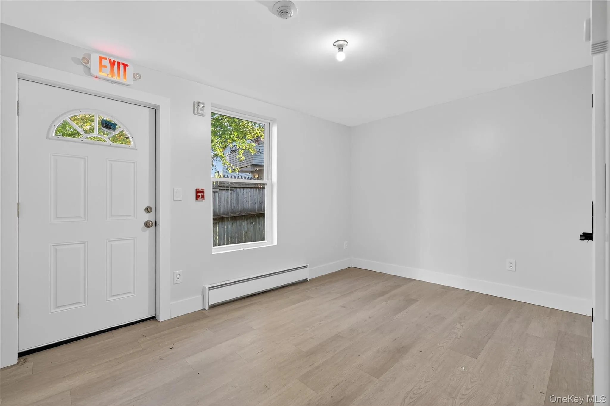 Entrance foyer with baseboard heating, healthy amount of natural light, and light wood-style floors Entrance foyer with baseboard heating, healthy amount of natural light, and light wood-style floors