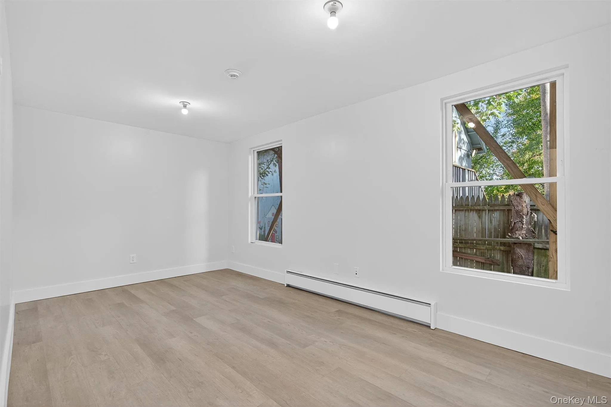 Spare room featuring a baseboard radiator and light wood-style floors Spare room featuring a baseboard radiator and light wood-style floors