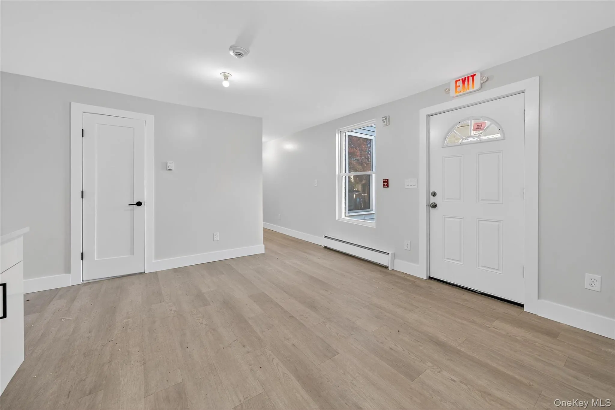 Entrance foyer featuring baseboard heating and light wood-style floors Entrance foyer featuring baseboard heating and light wood-style floors
