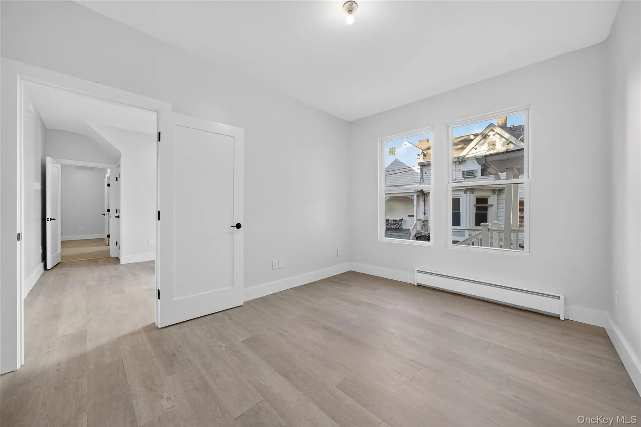 Unfurnished room featuring a baseboard radiator and light wood-type flooring Unfurnished room featuring a baseboard radiator and light wood-type flooring