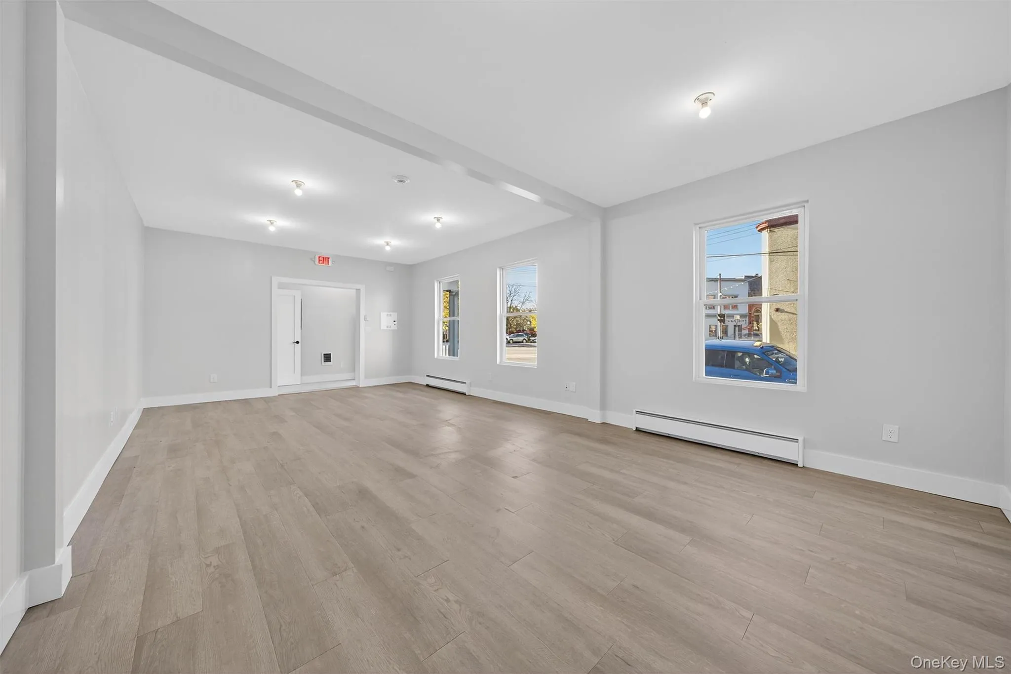 Empty room featuring light wood-style flooring and a baseboard radiator Empty room featuring light wood-style flooring and a baseboard radiator