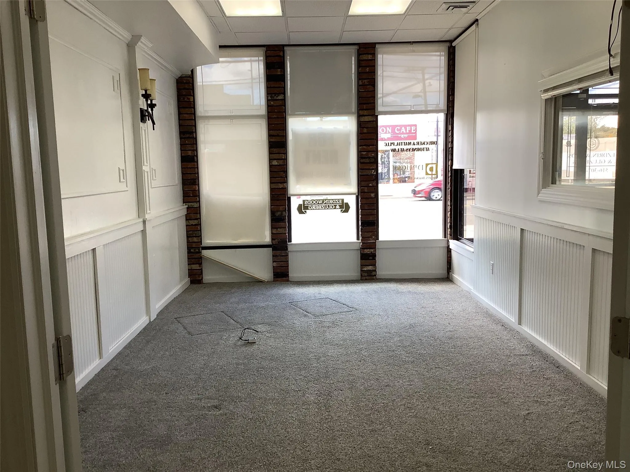 Carpeted spare room with a paneled ceiling and healthy amount of natural light Carpeted spare room with a paneled ceiling and healthy amount of natural light