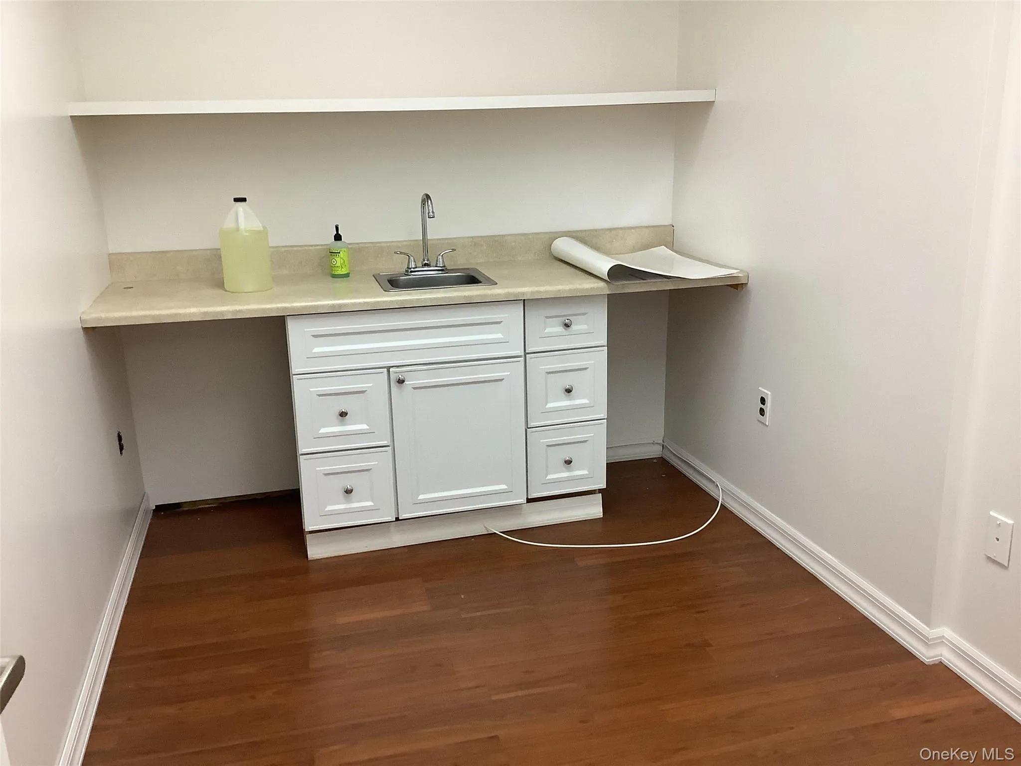 Bar with white cabinetry and dark wood-style flooring Bar with white cabinetry and dark wood-style flooring