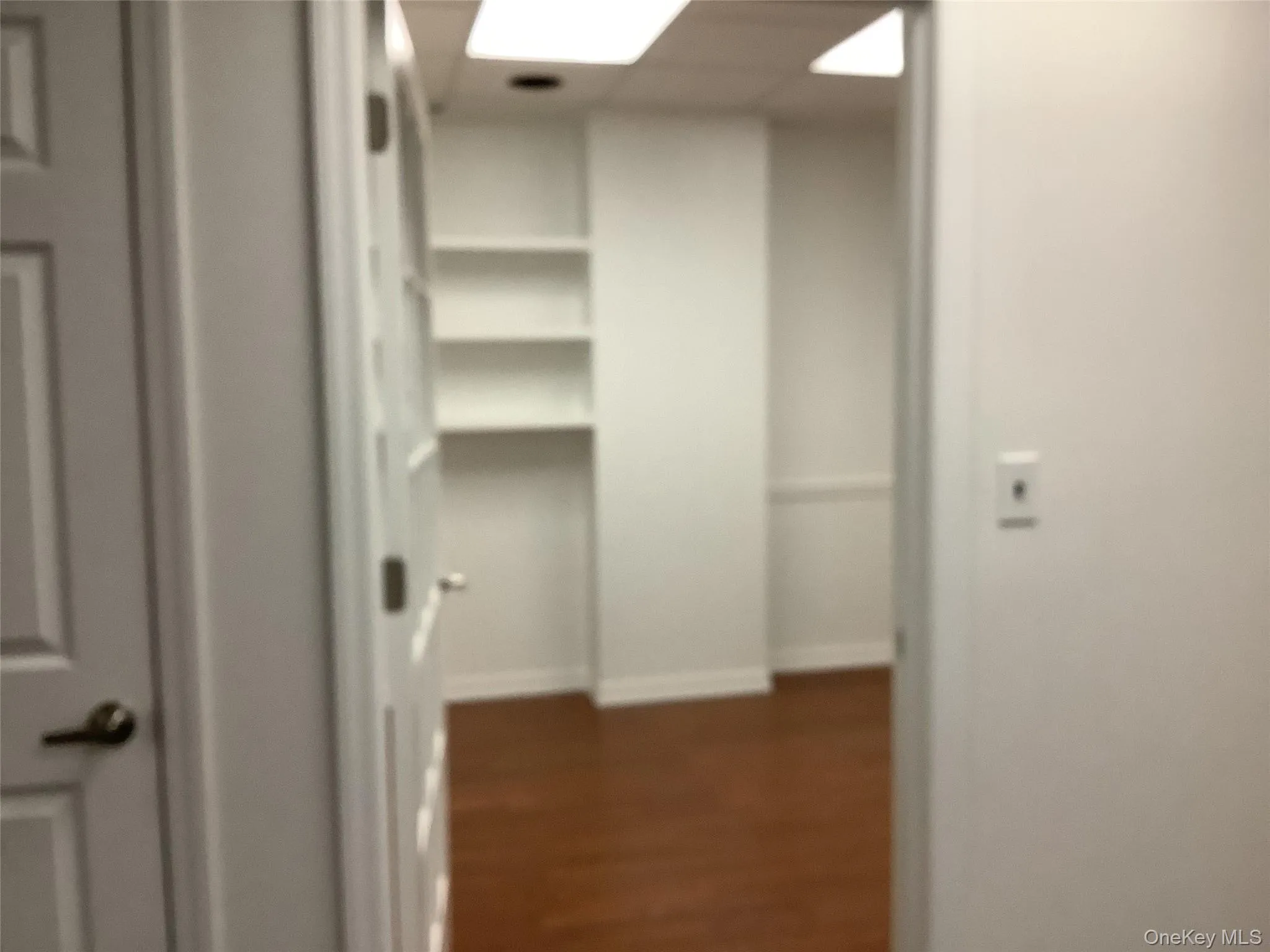 Hallway featuring dark wood-style flooring and baseboards Hallway featuring dark wood-style flooring and baseboards