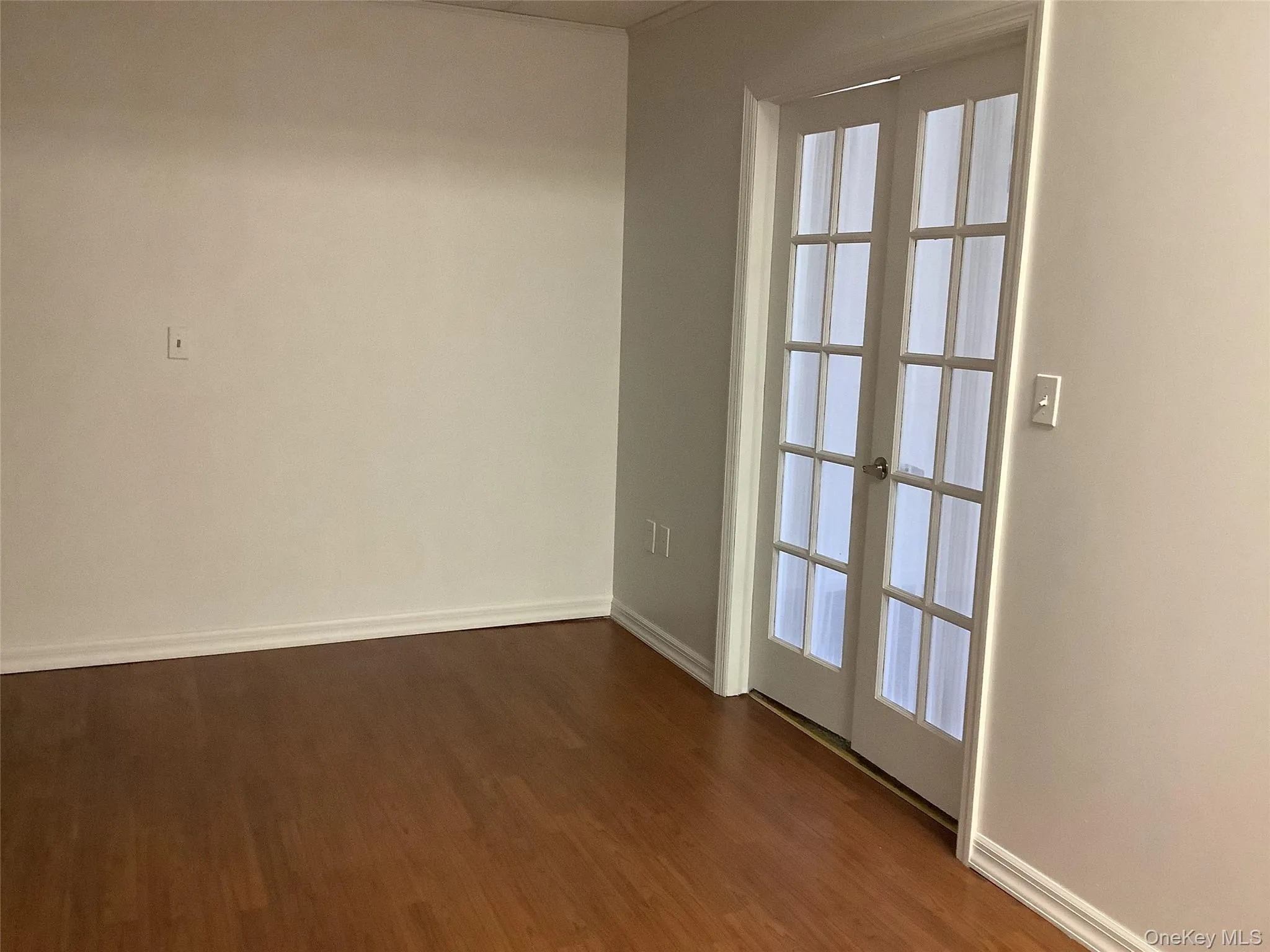 Empty room featuring dark wood finished floors and french doors Empty room featuring dark wood finished floors and french doors