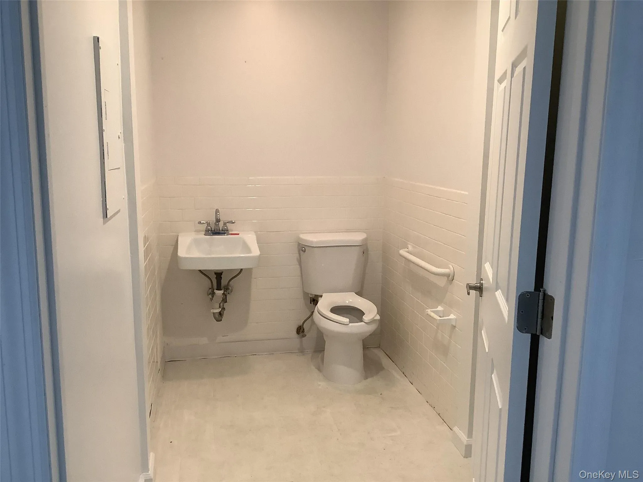 Bathroom featuring wainscoting and tile walls Bathroom featuring wainscoting and tile walls
