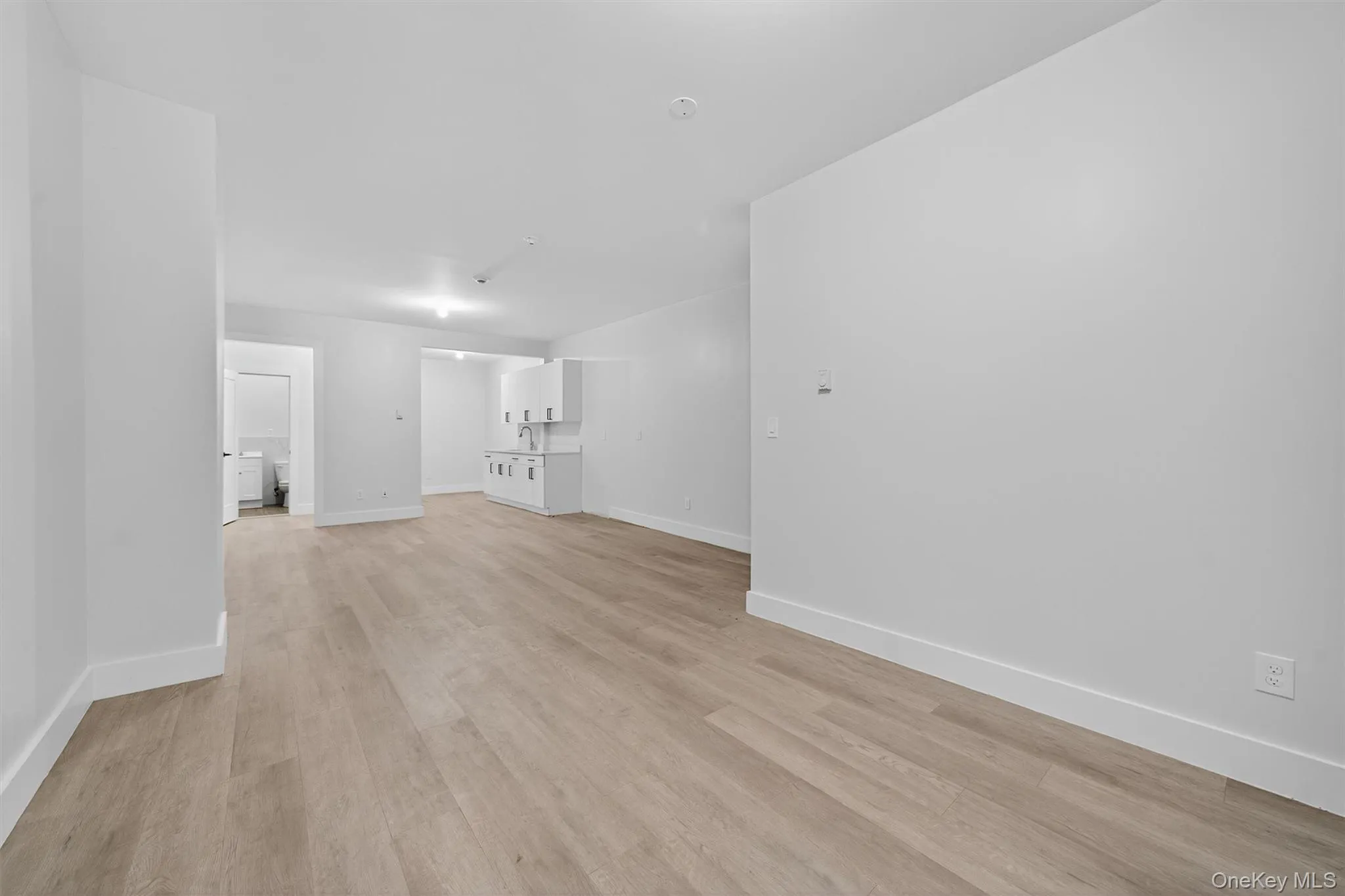 Unfurnished living room with baseboards and light wood-style floors Unfurnished living room with baseboards and light wood-style floors