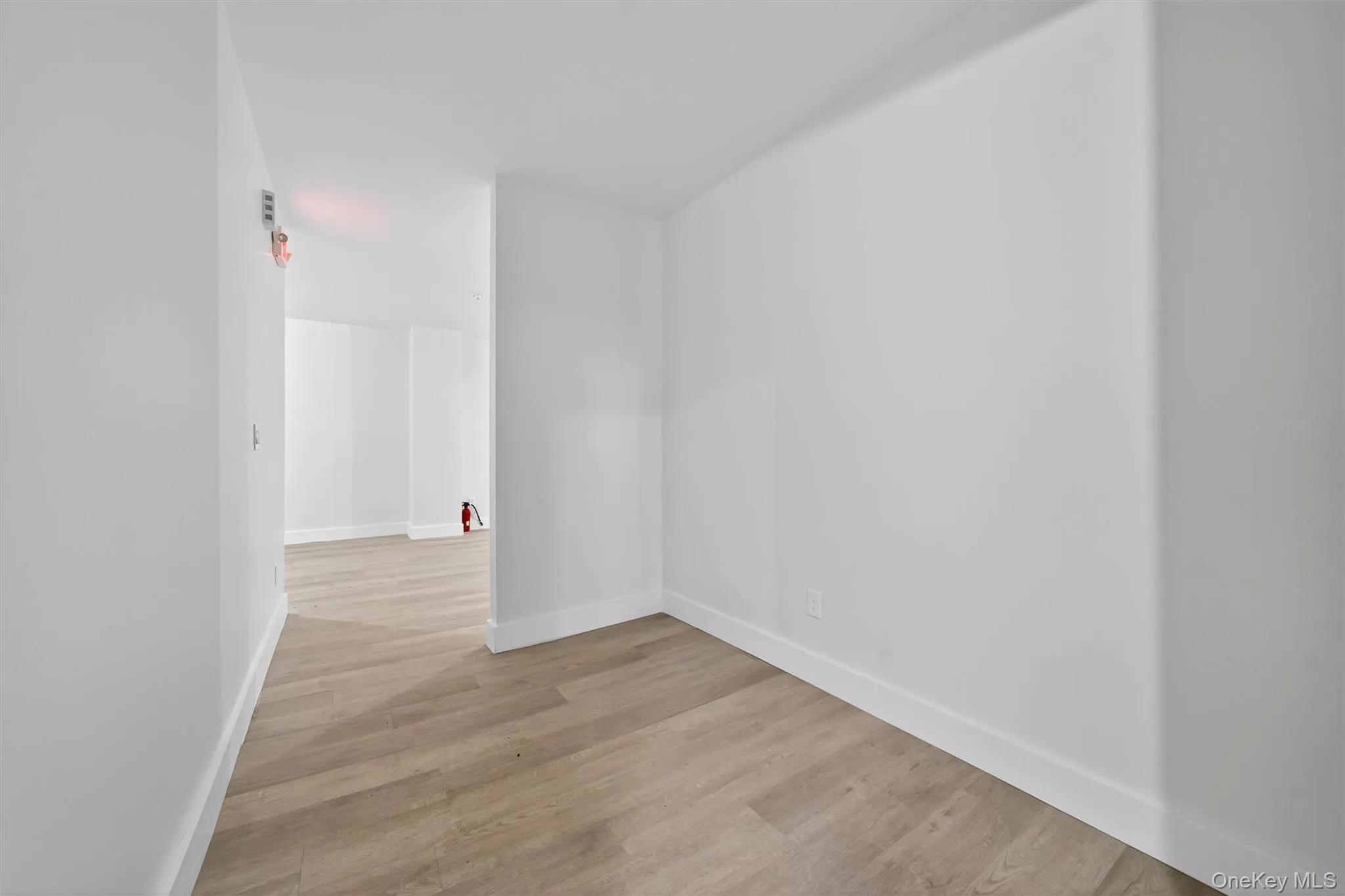 Unfurnished room with light wood finished floors and baseboards Unfurnished room with light wood finished floors and baseboards