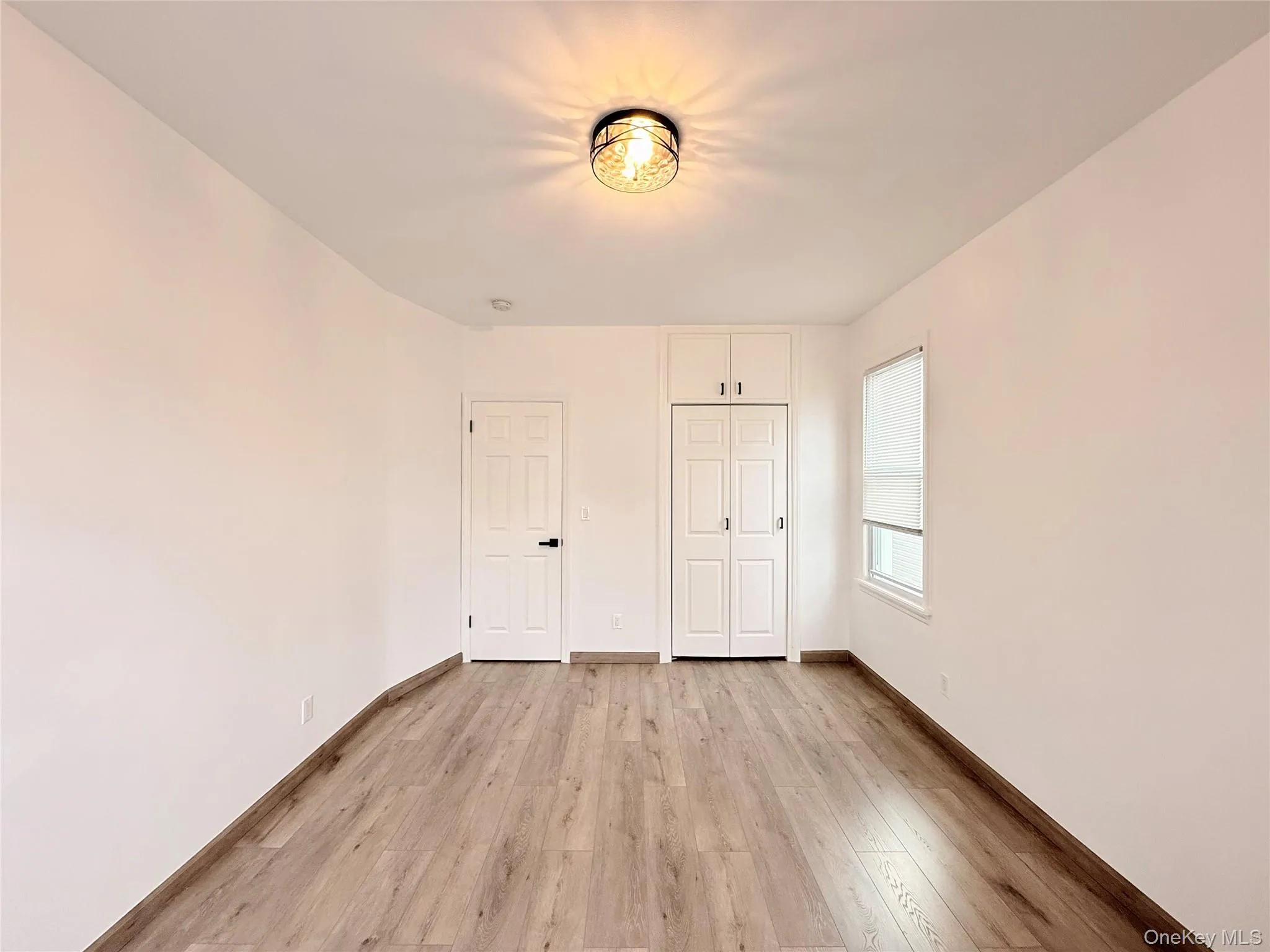Unfurnished bedroom featuring light wood-style flooring and a closet Unfurnished bedroom featuring light wood-style flooring and a closet