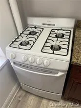 View of white range with gas stovetop and light wood-type flooring View of white range with gas stovetop and light wood-type flooring