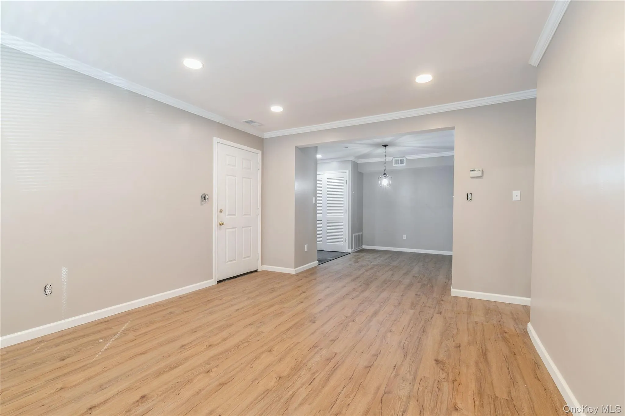 Spare room with ornamental molding, light wood-style flooring, and recessed lighting Spare room with ornamental molding, light wood-style flooring, and recessed lighting