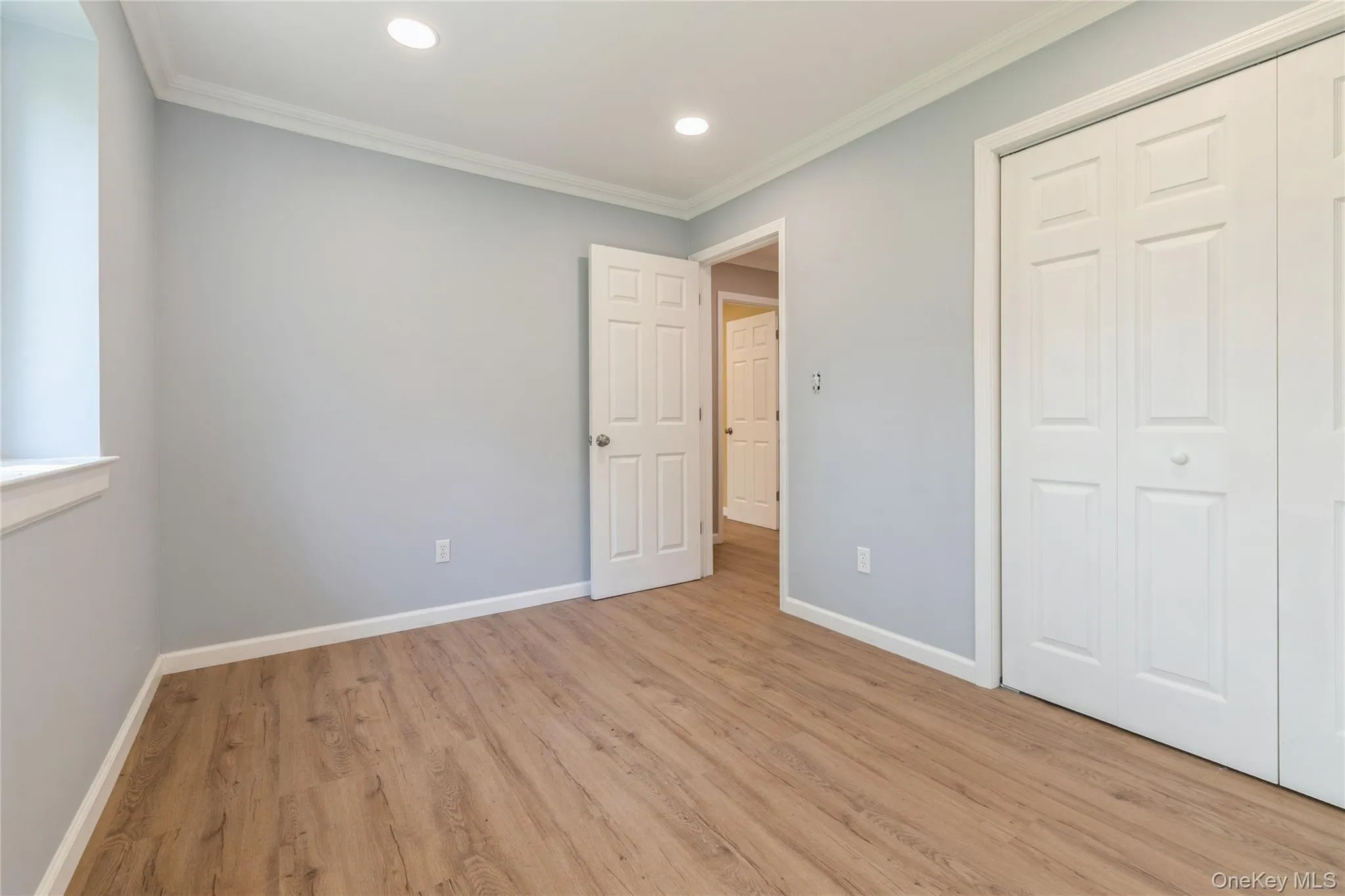 Unfurnished bedroom featuring crown molding, light wood-style floors, a closet, and recessed lighting Unfurnished bedroom featuring crown molding, light wood-style floors, a closet, and recessed lighting