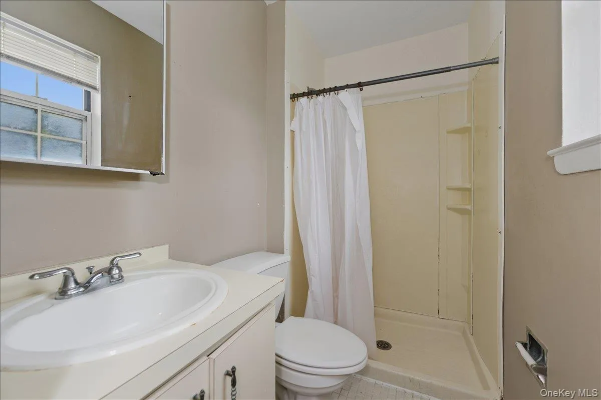 Bathroom with a stall shower, vanity, and light tile patterned flooring Bathroom with a stall shower, vanity, and light tile patterned flooring