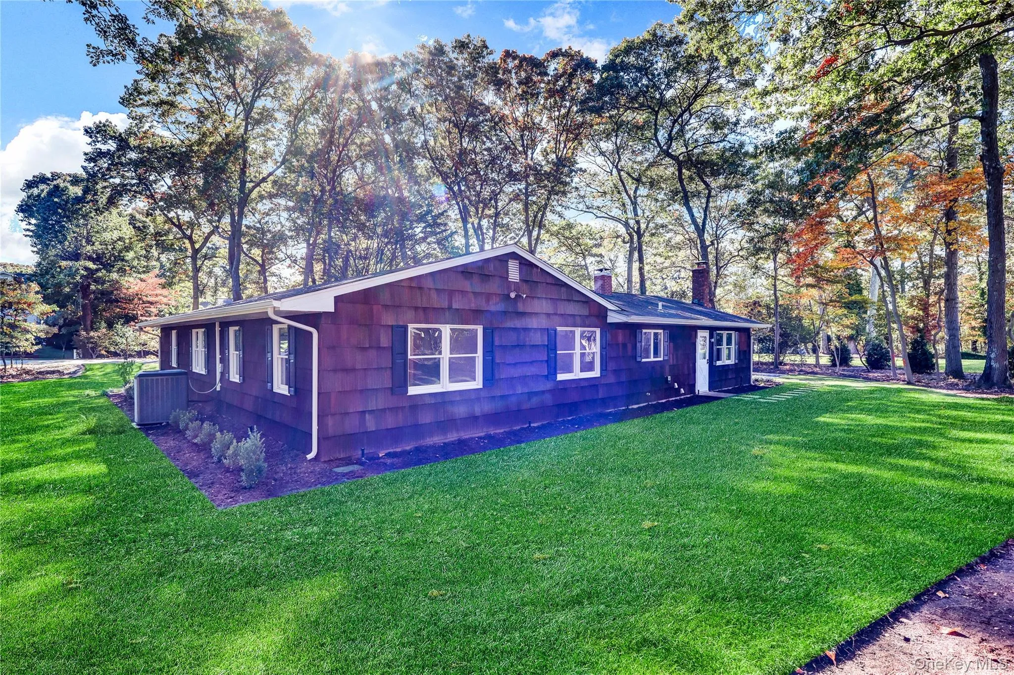 View of side of property with a lawn, a chimney, and view of scattered trees View of side of property with a lawn, a chimney, and view of scattered trees