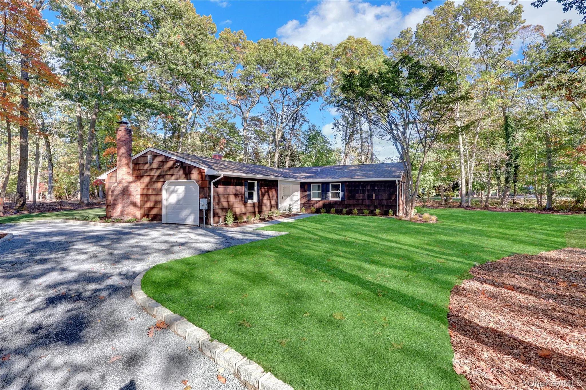 View of front of home featuring a chimney, a front yard, asphalt driveway, and an attached garage View of front of home featuring a chimney, a front yard, asphalt driveway, and an attached garage