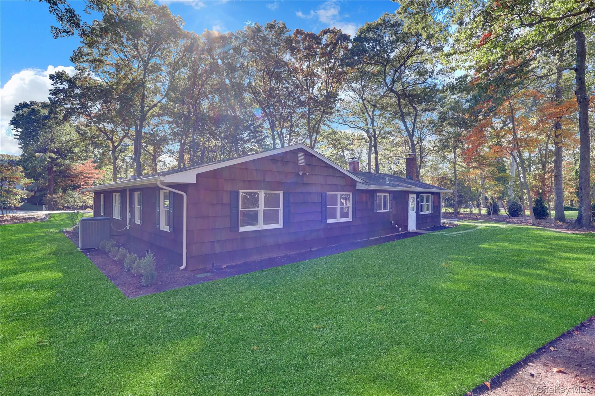 View of side of property featuring a yard, a chimney, and view of wooded area View of side of property featuring a yard, a chimney, and view of wooded area
