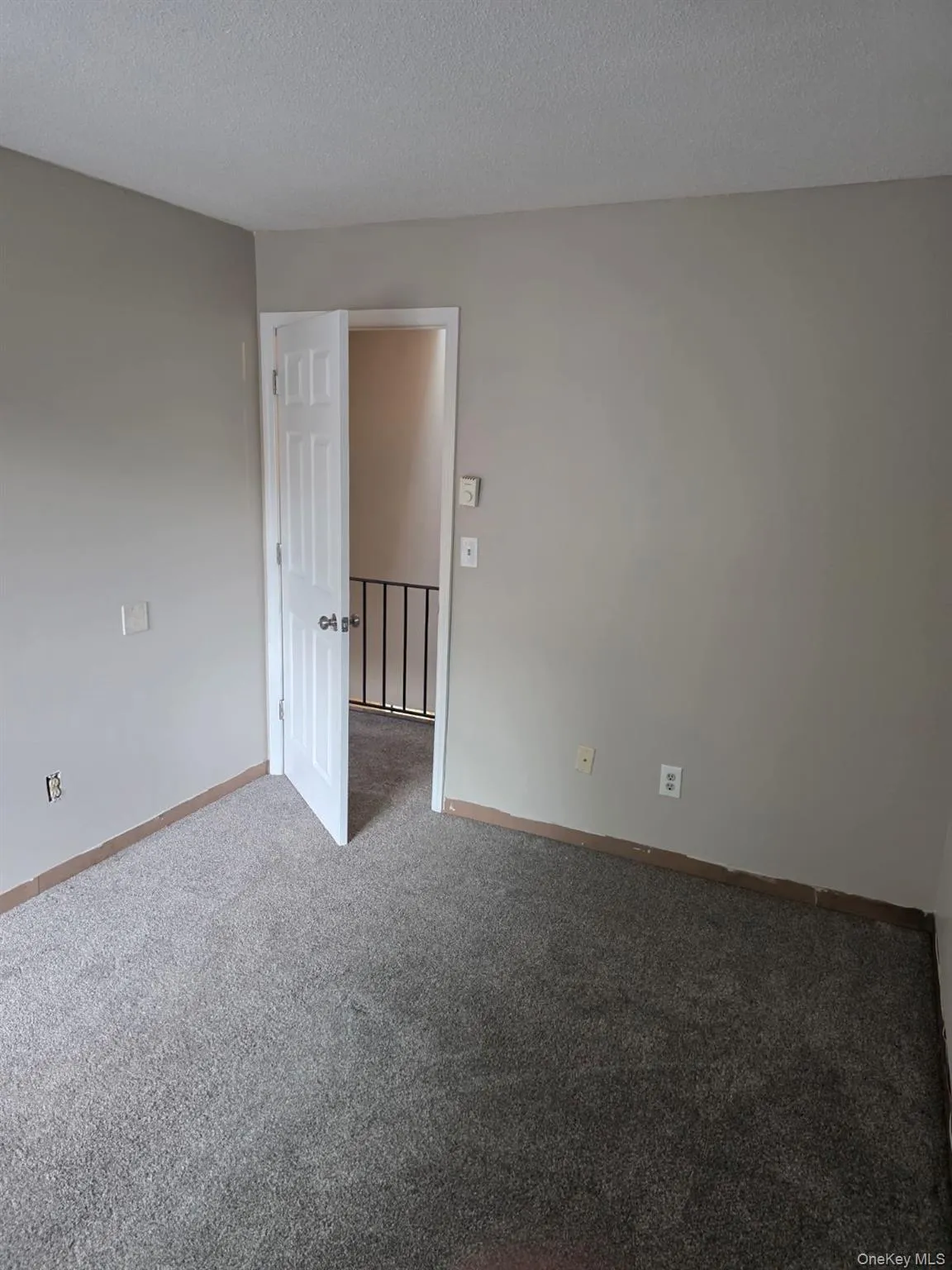 Empty room with a textured ceiling and carpet Empty room with a textured ceiling and carpet
