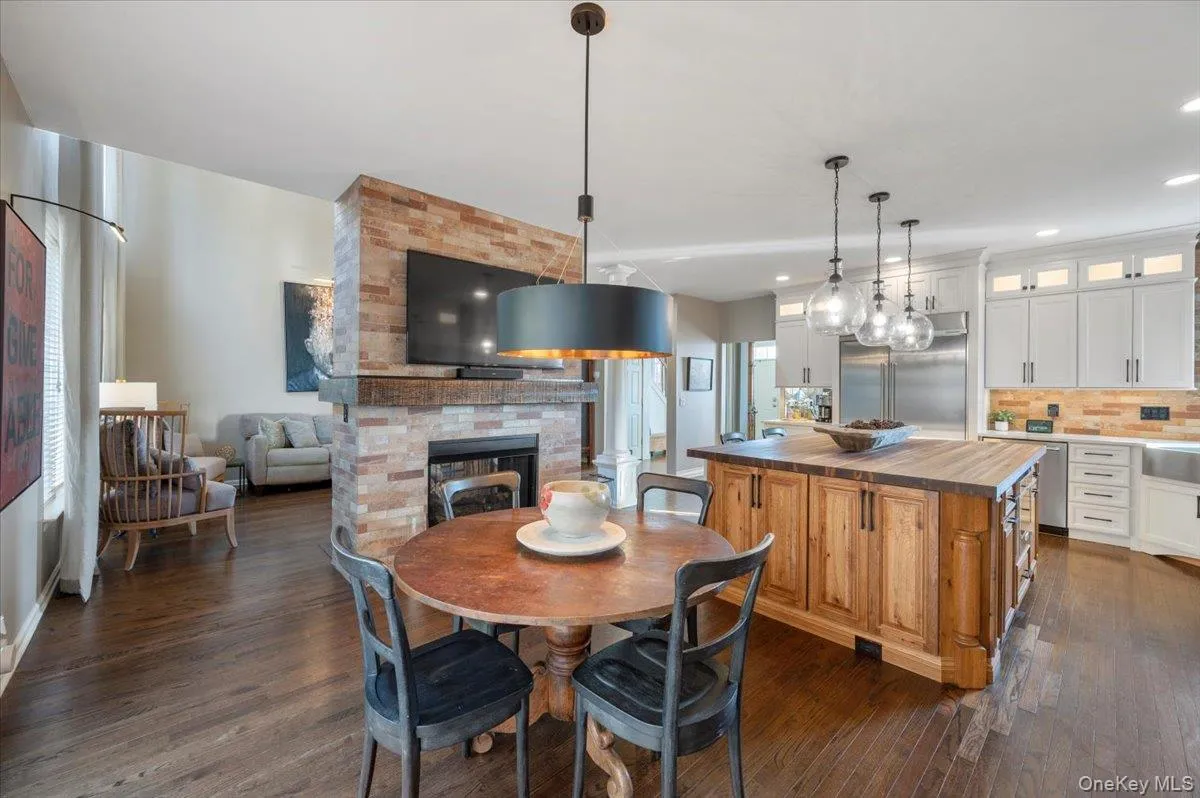 Dining room featuring a large fireplace and dark wood-style floors Dining room featuring a large fireplace and dark wood-style floors