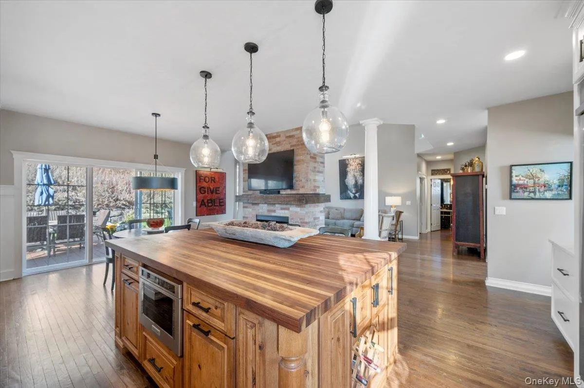 Kitchen featuring wooden counters, open floor plan, dark wood-style flooring, pendant lighting, and recessed lighting Kitchen featuring wooden counters, open floor plan, dark wood-style flooring, pendant lighting, and recessed lighting