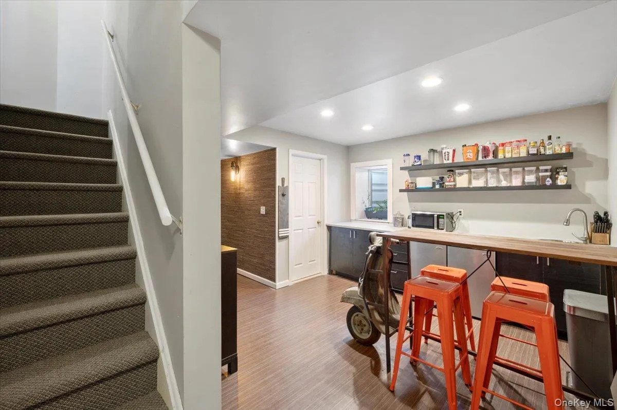 Bar area featuring butcher block counters, stairs, recessed lighting, light wood-style floors, and open shelves Bar area featuring butcher block counters, stairs, recessed lighting, light wood-style floors, and open shelves