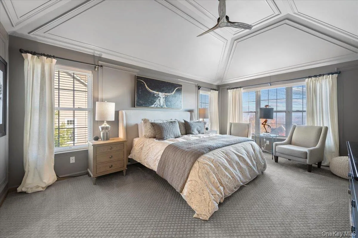 Carpeted bedroom with vaulted ceiling, ceiling fan, and crown molding Carpeted bedroom with vaulted ceiling, ceiling fan, and crown molding