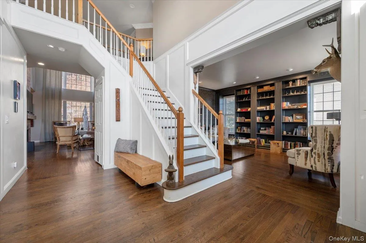Stairway featuring wood finished floors, recessed lighting, and a high ceiling Stairway featuring wood finished floors, recessed lighting, and a high ceiling