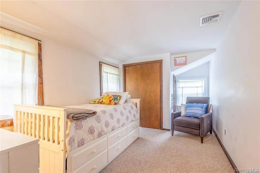 Bedroom featuring light carpet and a closet Bedroom featuring light carpet and a closet