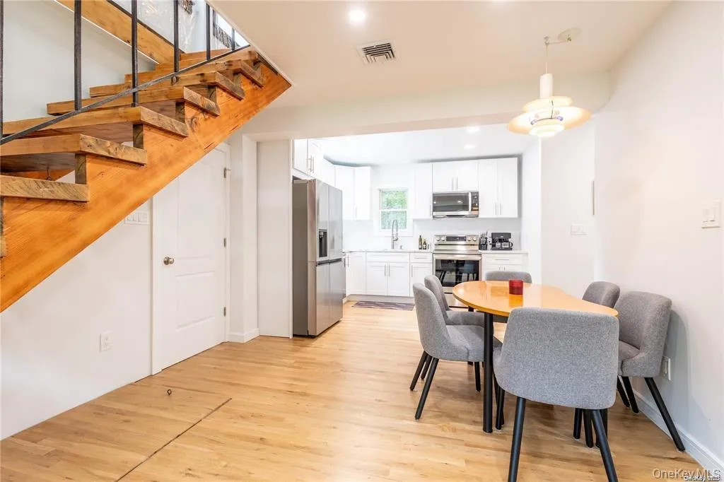 Dining room with light wood-style flooring, recessed lighting, and stairs Dining room with light wood-style flooring, recessed lighting, and stairs