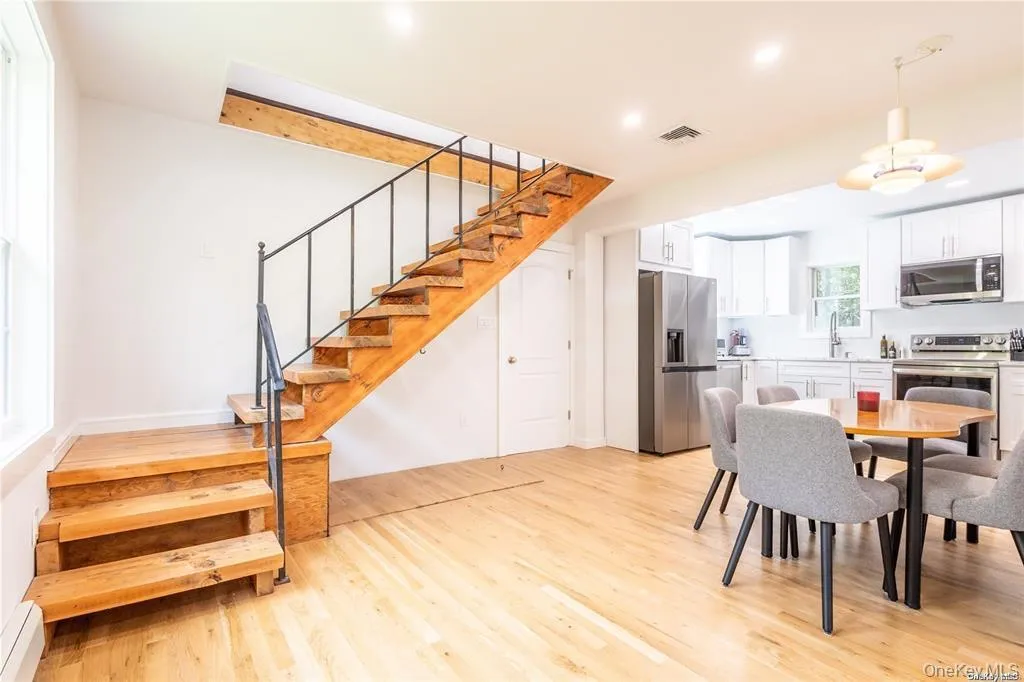 Dining space featuring stairs, light wood finished floors, baseboard heating, and recessed lighting Dining space featuring stairs, light wood finished floors, baseboard heating, and recessed lighting