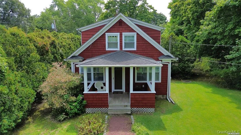 View of front of house featuring a sunroom, a front lawn, and a shingled roof View of front of house featuring a sunroom, a front lawn, and a shingled roof