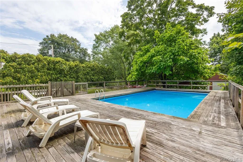 View of swimming pool with a deck and view of scattered trees View of swimming pool with a deck and view of scattered trees