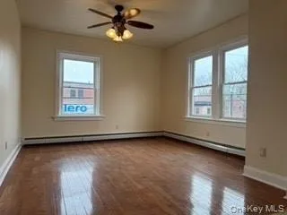 Empty room featuring ceiling fan, wood-type flooring, and baseboards Empty room featuring ceiling fan, wood-type flooring, and baseboards