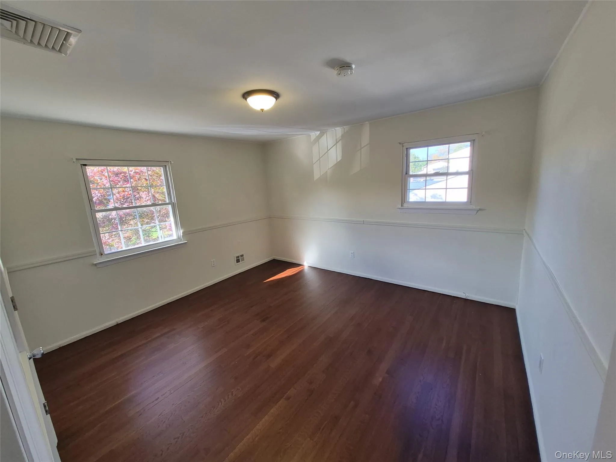 Empty room with dark wood finished floors Empty room with dark wood finished floors