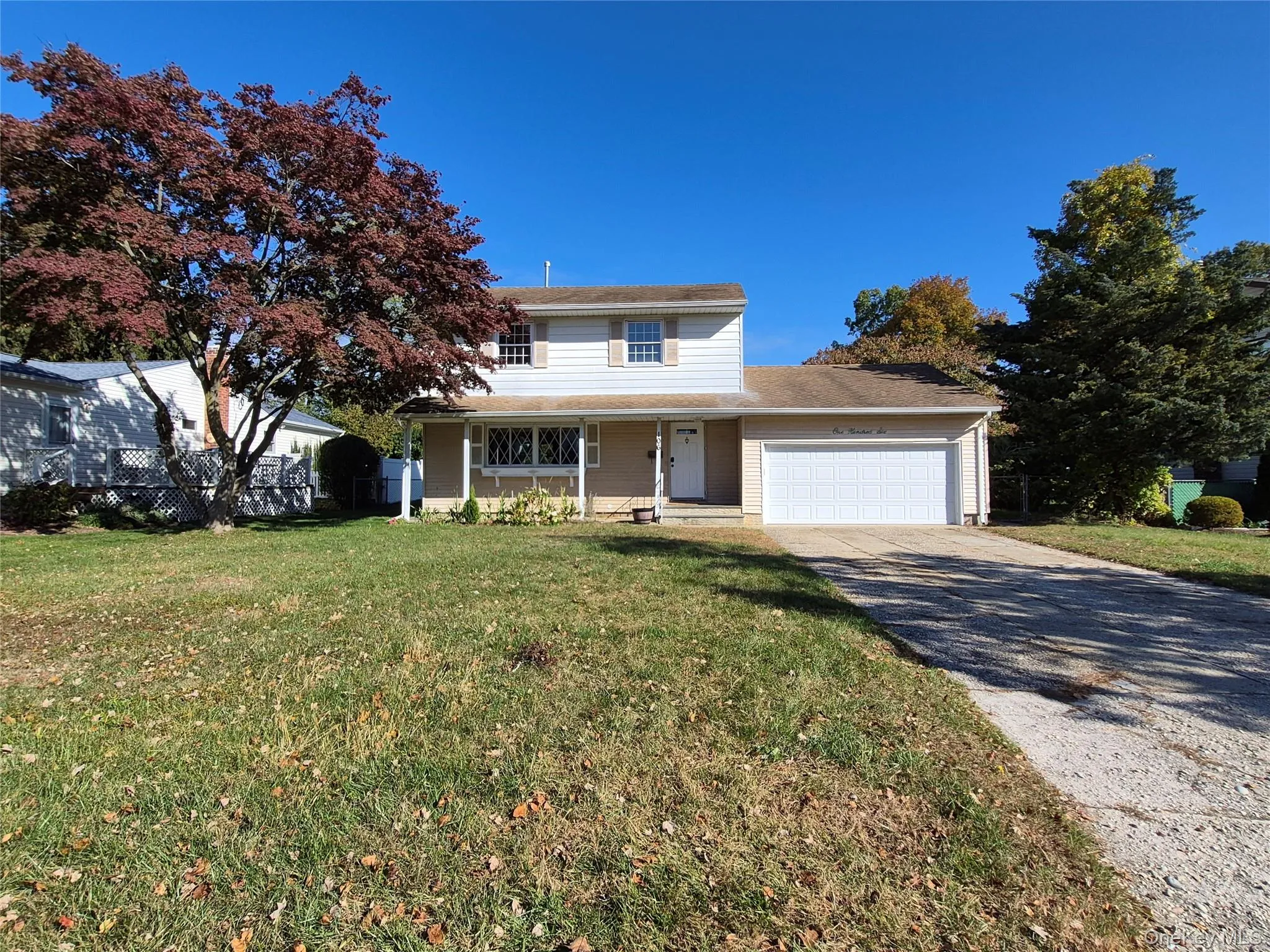 Traditional-style house featuring a porch, driveway, and a garage Traditional-style house featuring a porch, driveway, and a garage