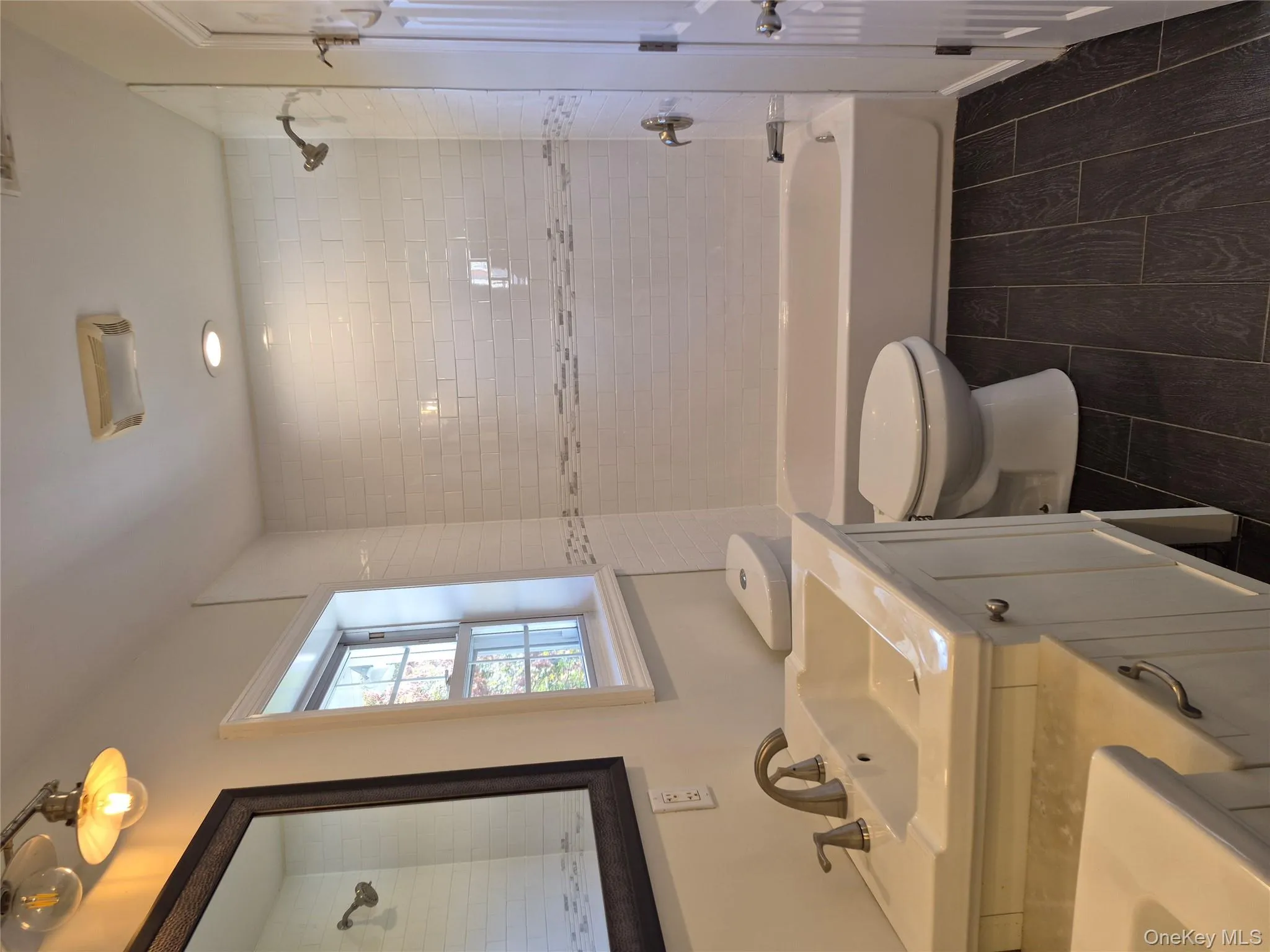 Bathroom with two vanities, shower / bath combination, and wood finish floors Bathroom with two vanities, shower / bath combination, and wood finish floors