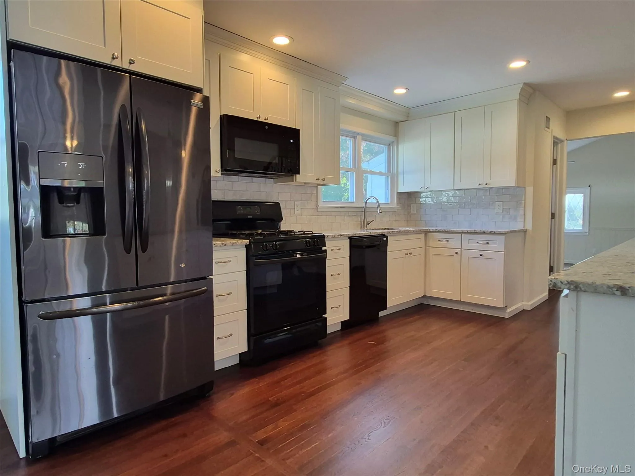 Kitchen featuring black appliances, plenty of natural light, white cabinets, and recessed lighting Kitchen featuring black appliances, plenty of natural light, white cabinets, and recessed lighting