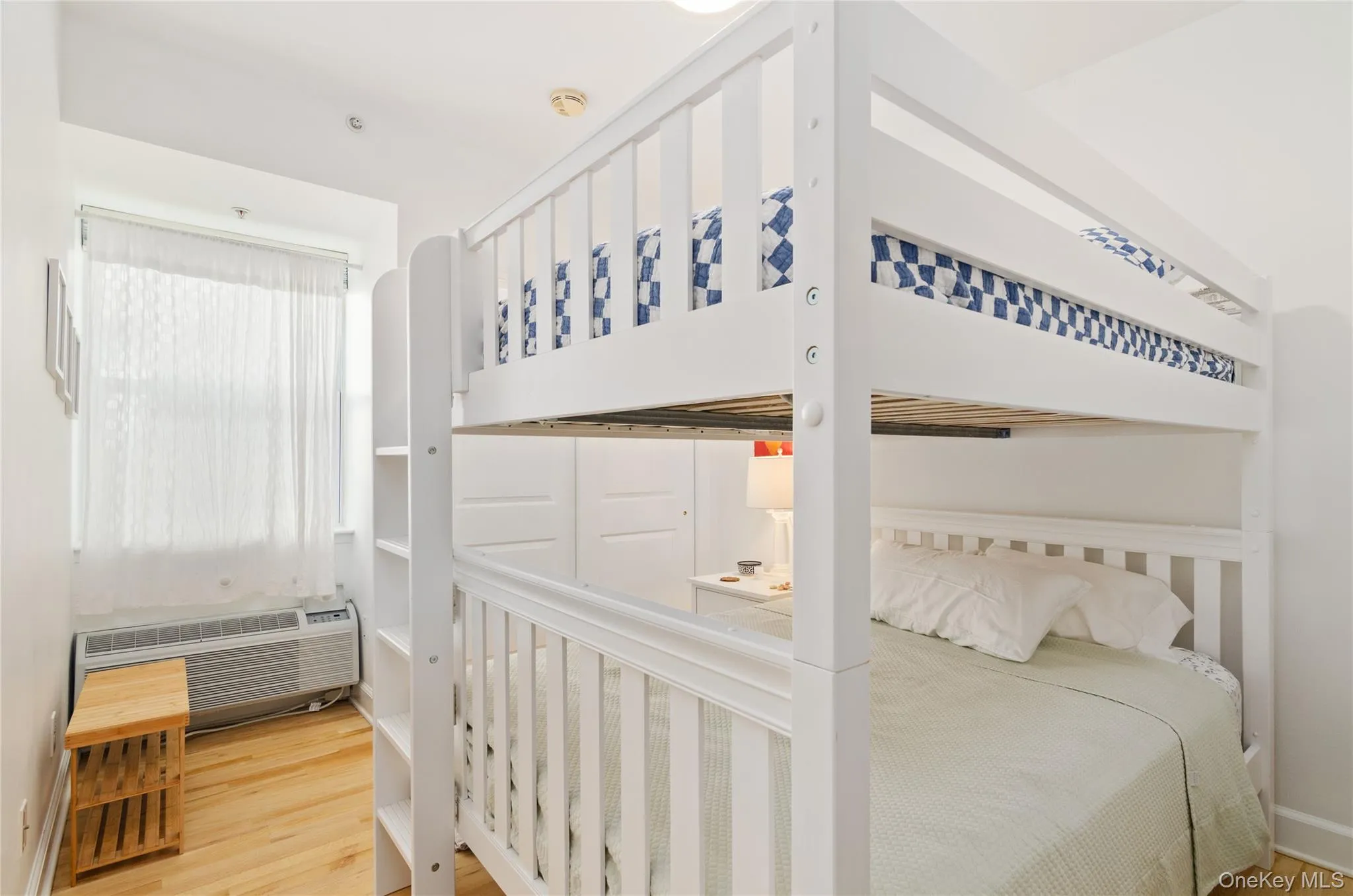 Bedroom featuring light wood-style flooring and an AC wall unit Bedroom featuring light wood-style flooring and an AC wall unit