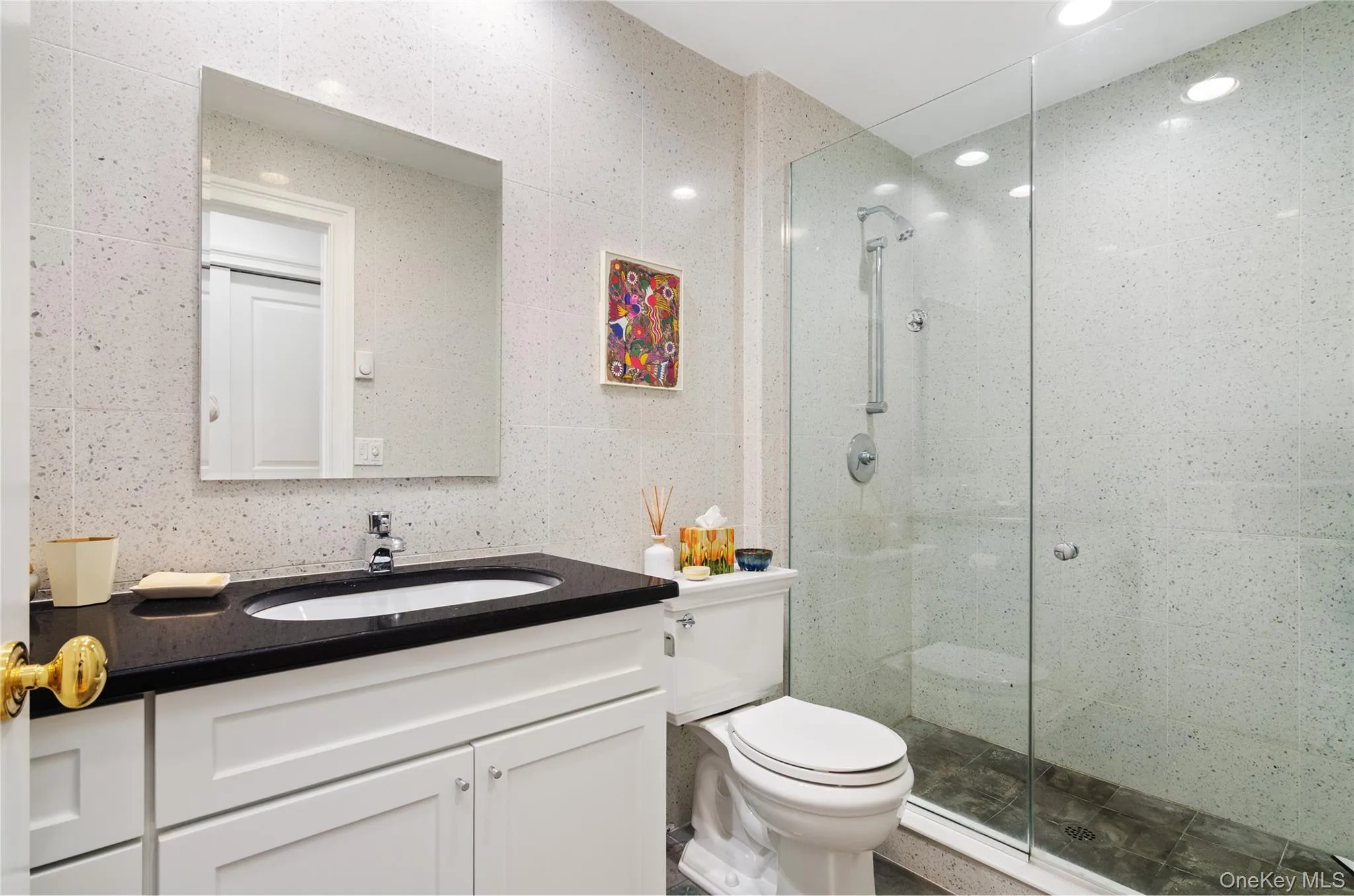 Bathroom with vanity, a shower stall, tile walls, and recessed lighting Bathroom with vanity, a shower stall, tile walls, and recessed lighting