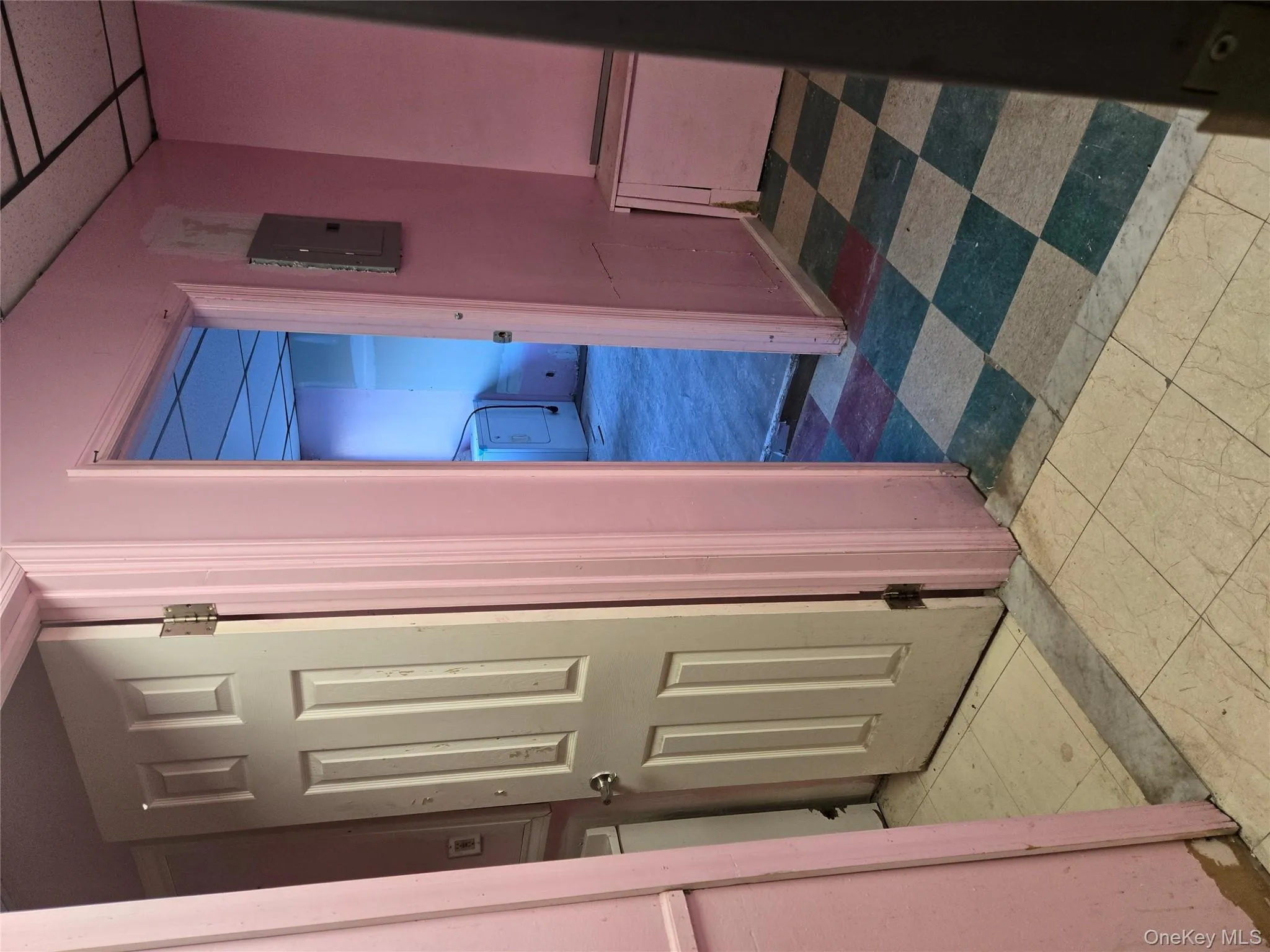 Hall featuring a paneled ceiling, electric panel, light floors, and washer / dryer Hall featuring a paneled ceiling, electric panel, light floors, and washer / dryer