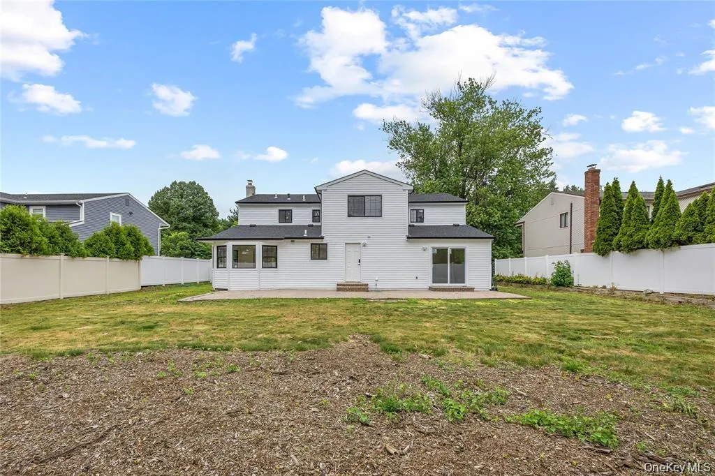 Back of house with a patio area, a fenced backyard, and a chimney Back of house with a patio area, a fenced backyard, and a chimney