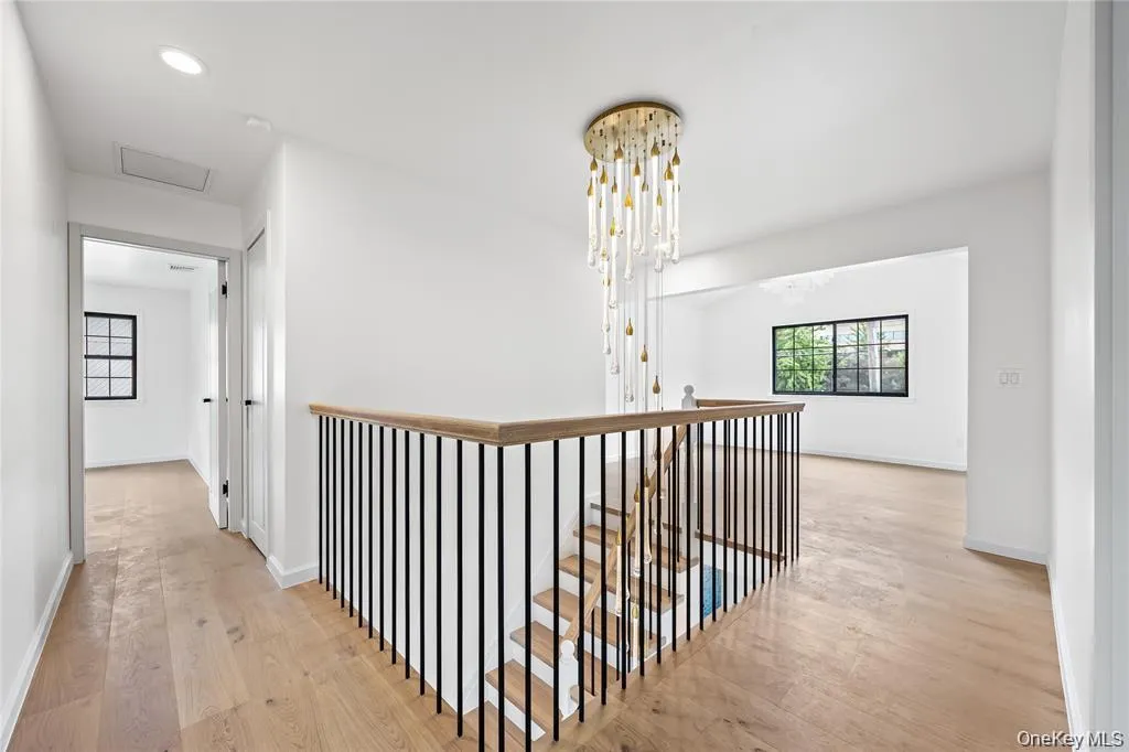 Hall featuring an upstairs landing, light wood-type flooring, recessed lighting, attic access, and a chandelier Hall featuring an upstairs landing, light wood-type flooring, recessed lighting, attic access, and a chandelier