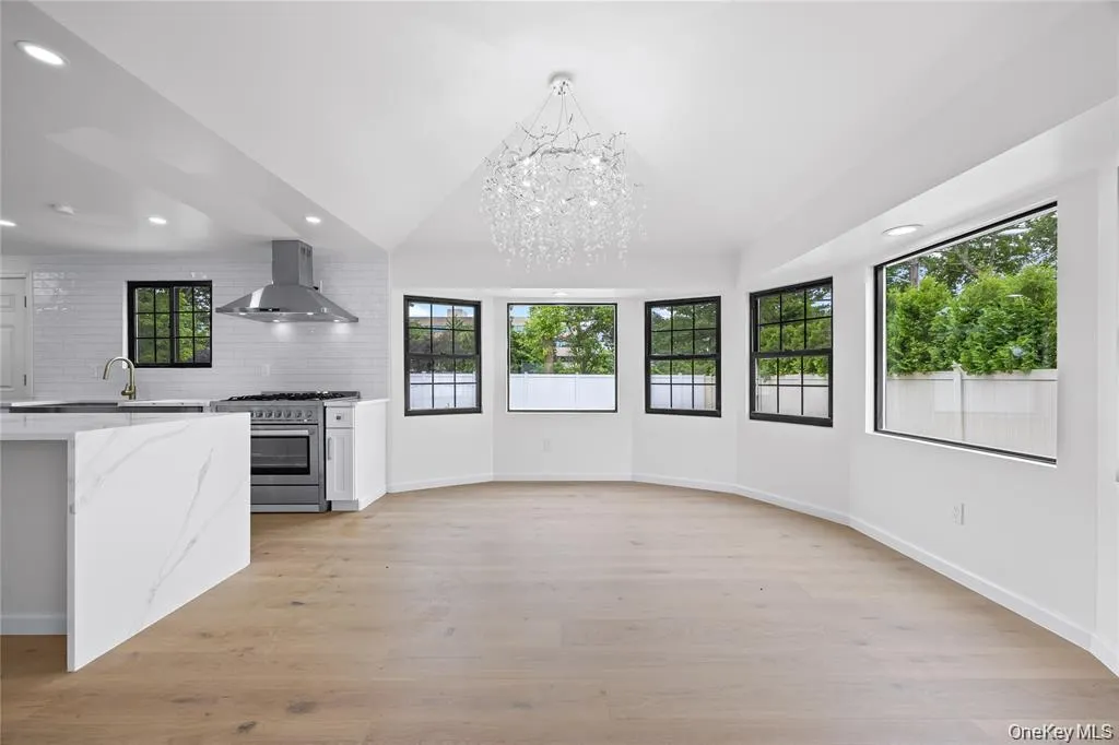 Kitchen featuring backsplash, recessed lighting, light wood finished floors, a chandelier, and high end stainless steel range oven Kitchen featuring backsplash, recessed lighting, light wood finished floors, a chandelier, and high end stainless steel range oven