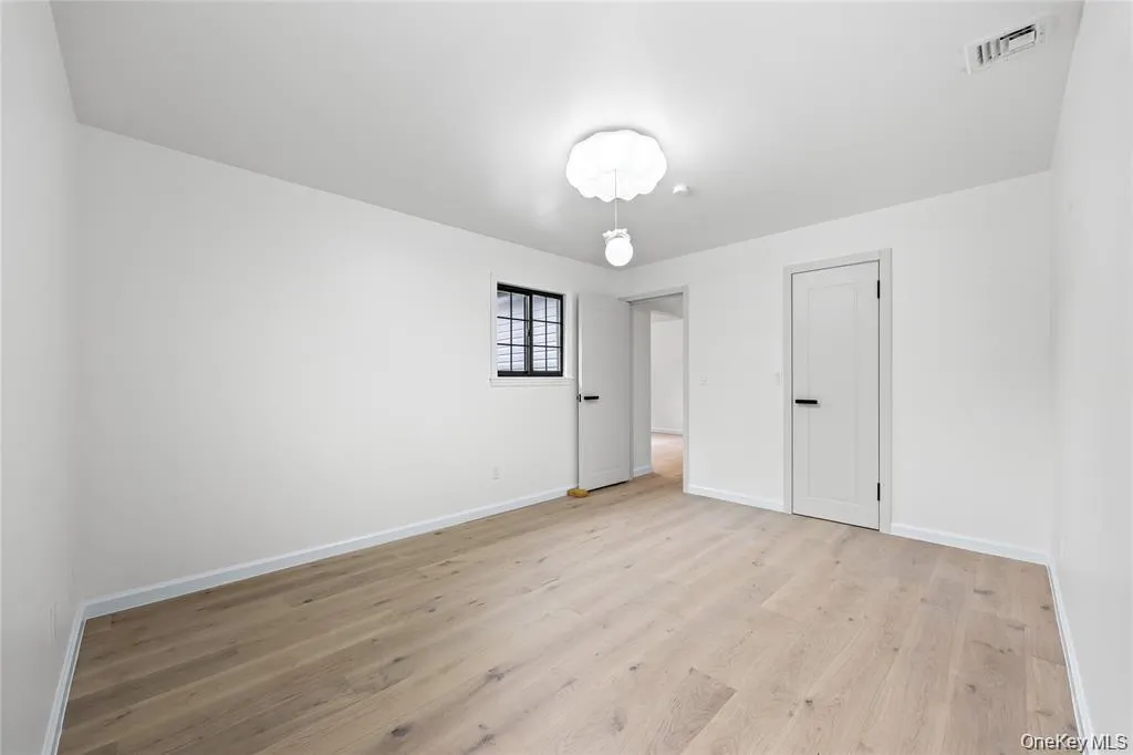 Unfurnished bedroom with light wood finished floors and baseboards Unfurnished bedroom with light wood finished floors and baseboards