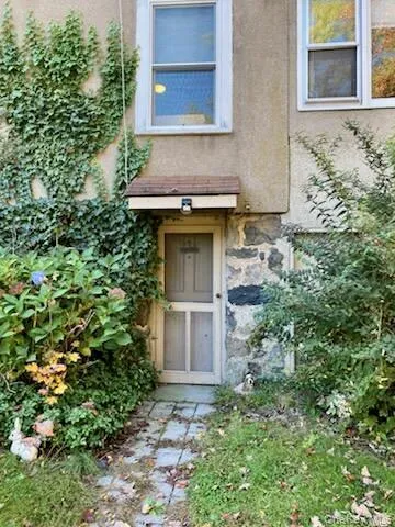 Doorway to property featuring stone siding and stucco siding Doorway to property featuring stone siding and stucco siding