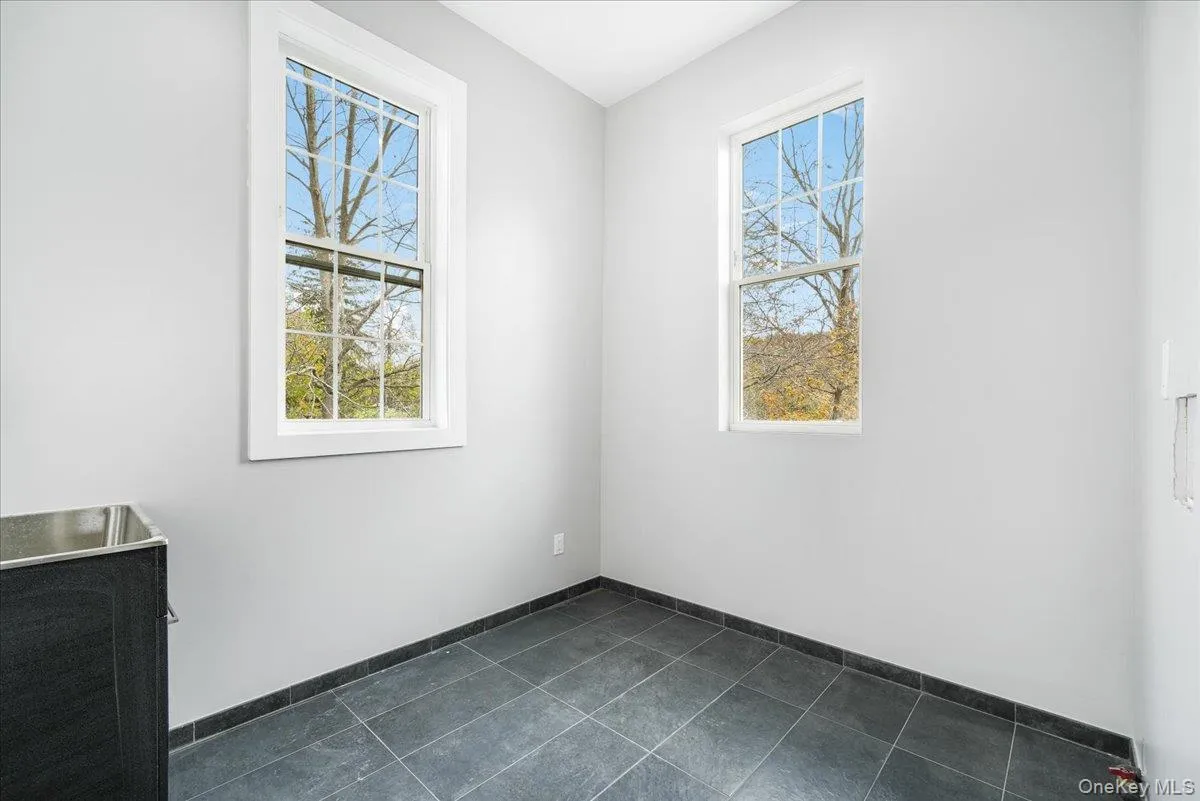 Unfurnished room with dark tile patterned floors Unfurnished room with dark tile patterned floors