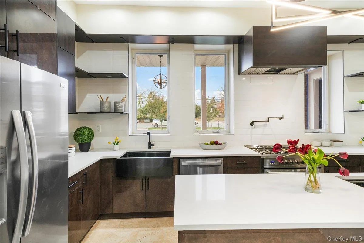 Kitchen with open shelves, appliances with stainless steel finishes, decorative backsplash, and dark brown cabinetry Kitchen with open shelves, appliances with stainless steel finishes, decorative backsplash, and dark brown cabinetry