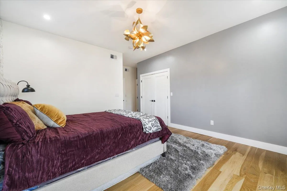 Bedroom featuring light wood-style flooring and a chandelier Bedroom featuring light wood-style flooring and a chandelier