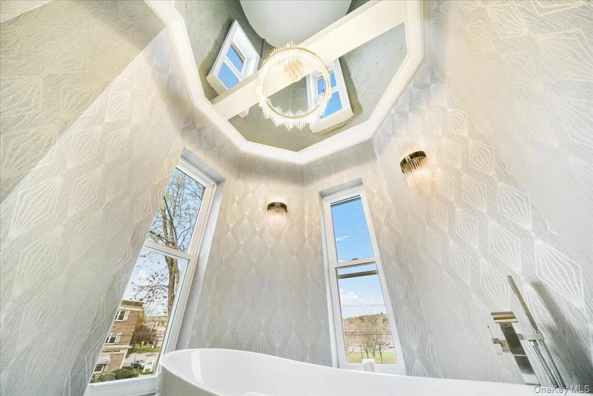 Full bath featuring a towering ceiling and a freestanding bath Full bath featuring a towering ceiling and a freestanding bath