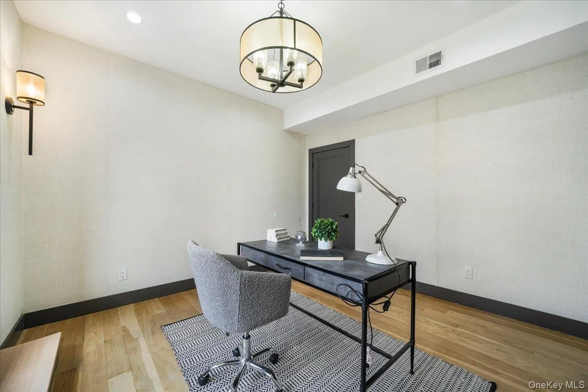 Office space with light wood finished floors, recessed lighting, and a chandelier Office space with light wood finished floors, recessed lighting, and a chandelier